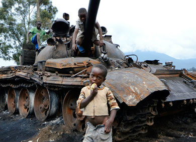 Crianças brincam em tanque destruído no Congo; violações aos direitos humanos agravam drama